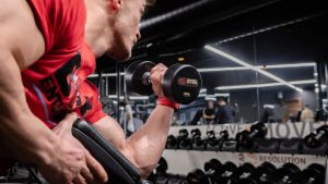 a man lifting a dumbbell in a gym